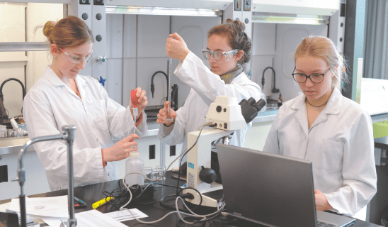 Trois étudiantes effectuant des analyses dans le laboratoire de chimie