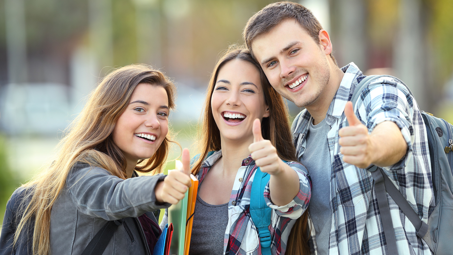 Trois étudiants souriant, le pouce en l'air