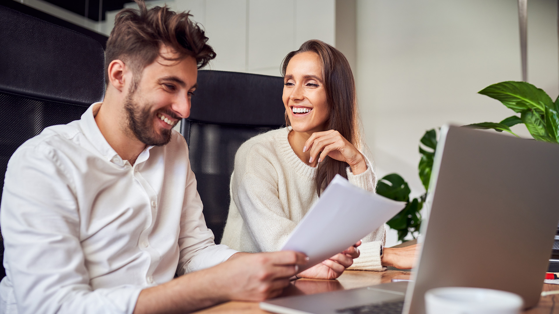 Deux adultes discutant devant un ordinateur