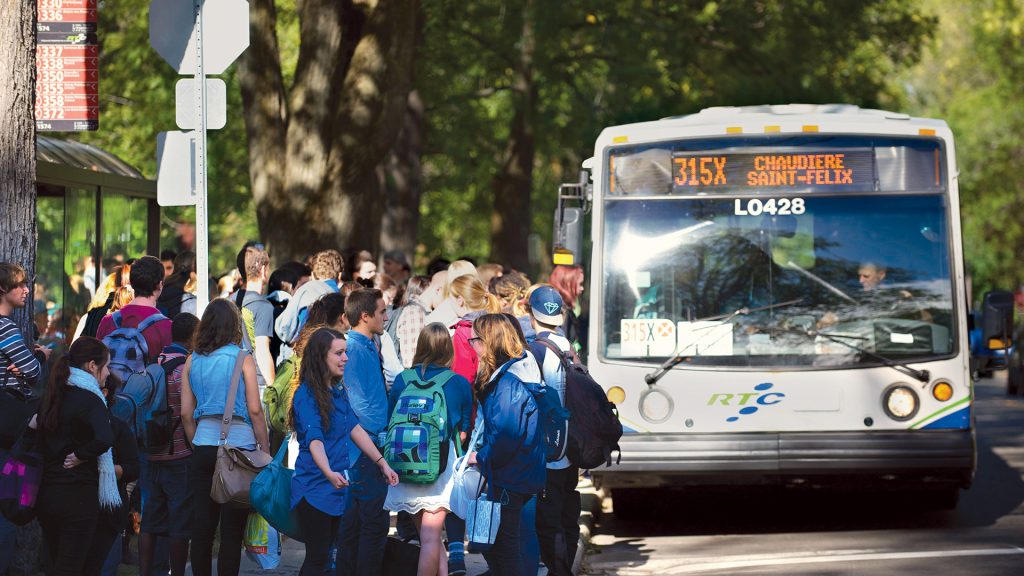 Arrêt d'autobus avec groupe d'étudiants montant dans un bus