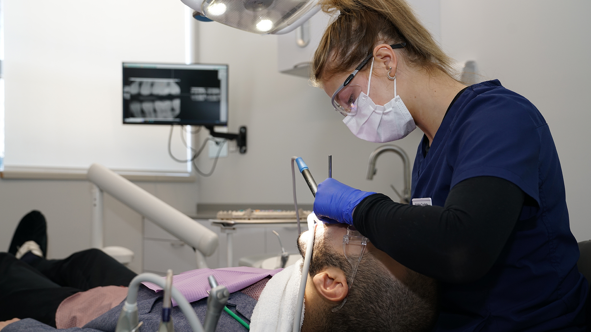 Étudiante prodiguant des soins dentaires à un patient