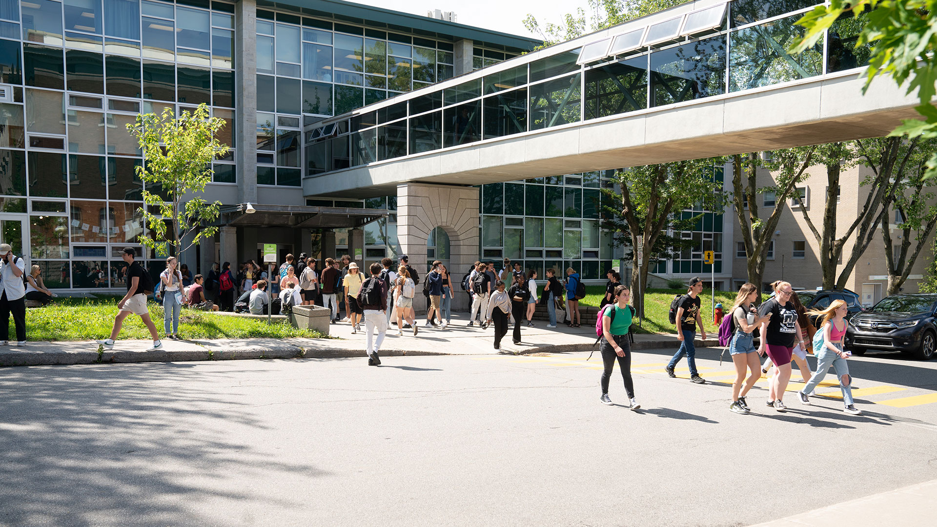 Étudiants sur le campus passant sous la passerelle