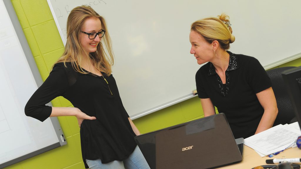 Professeur discutant avec une étudiante en classe