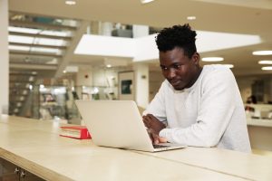 Étudiant travaillant à l'ordinateur à la bibliothèque