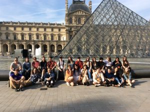 Groupe d'étudiants devant la pyramide du Louvre à Paris